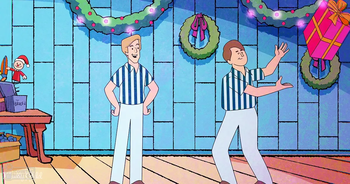 Two young adult males in casual striped shirts and light pants stand indoors with Christmas decorations including wreaths and wrapped gifts.