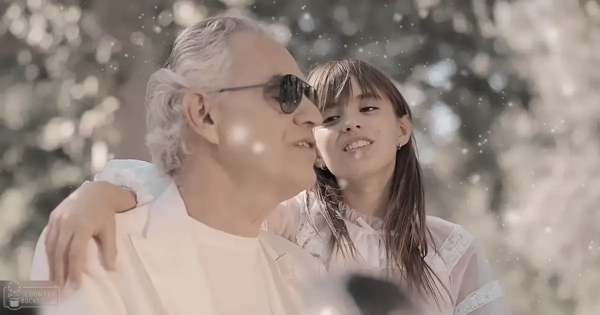 A young girl interacting with an older man under soft winter light, snowy outdoor setting