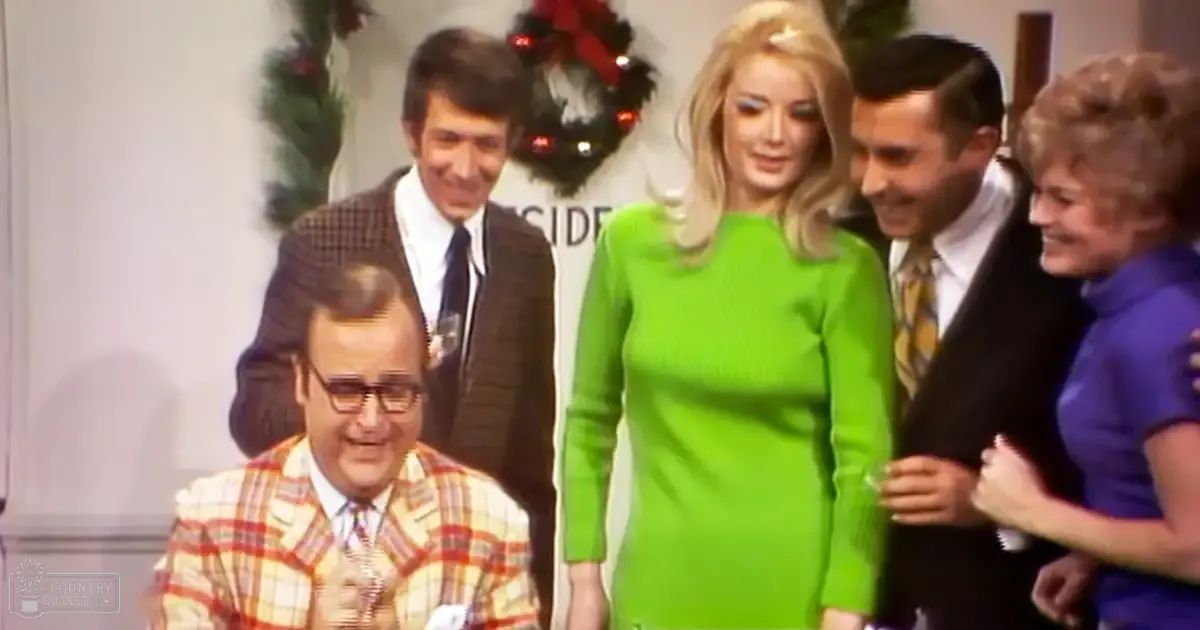 A group of adults gathered indoors for a formal or celebratory event with Christmas decorations in the background.