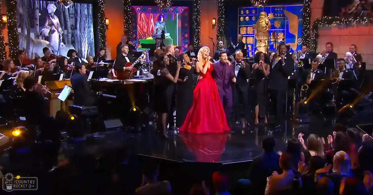 A performer in a red dress at an event or concert setting with musical instruments and festive decorations.