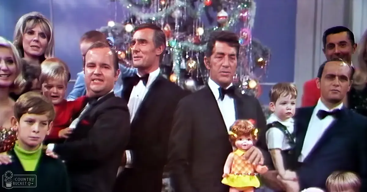 Festive indoor event with adults in formal attire, children playing around a decorated Christmas tree during daytime.