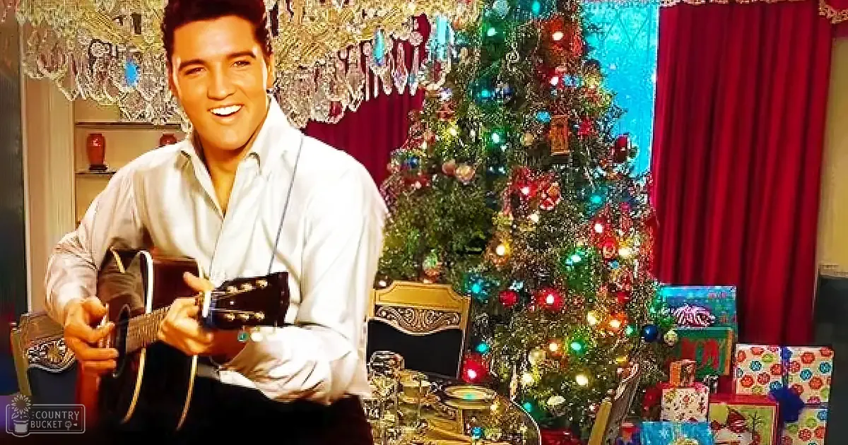 A man in a mid-20th-century inspired white shirt stands in front of a decorated Christmas tree with lights and ornaments, holding a guitar. The setting is indoors, likely in a living room at home during the daytime.