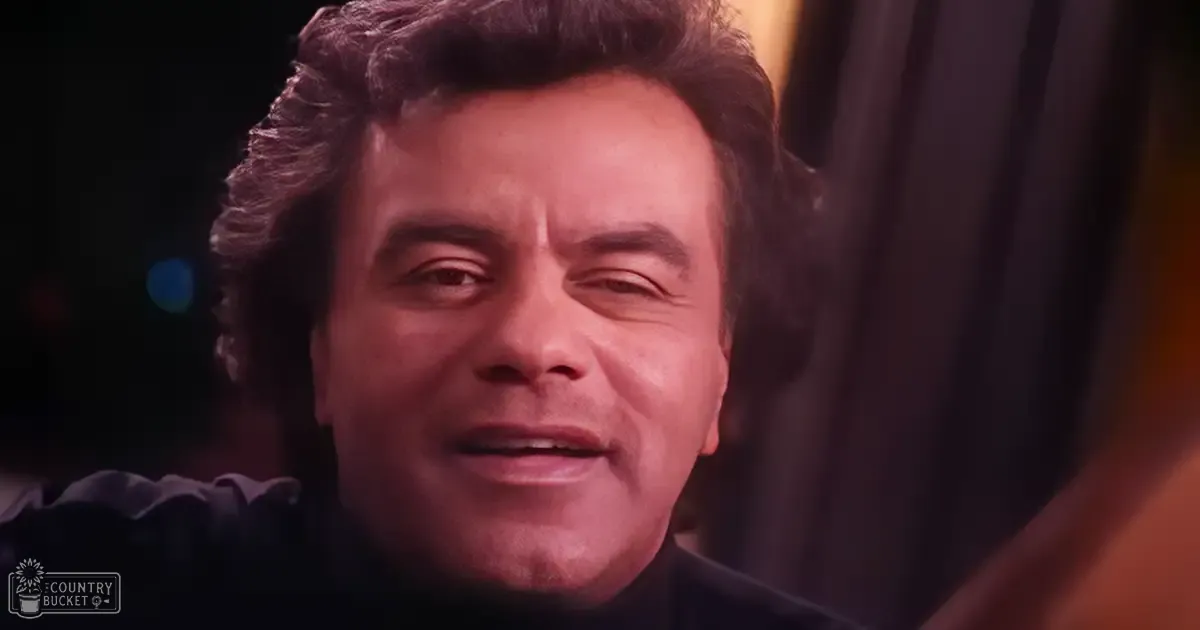 An adult male in a formal setting with dark attire; indoor event atmosphere.