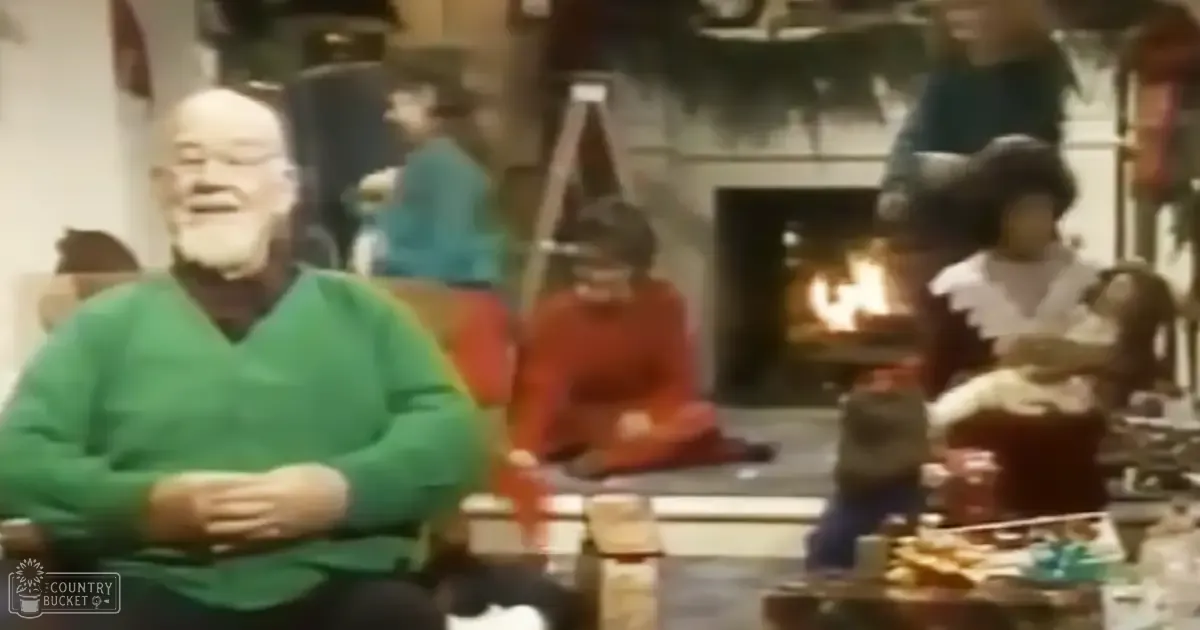 A cozy indoor living room with an older adult male in a green sweater sitting near a fireplace, surrounded by family members and furniture.