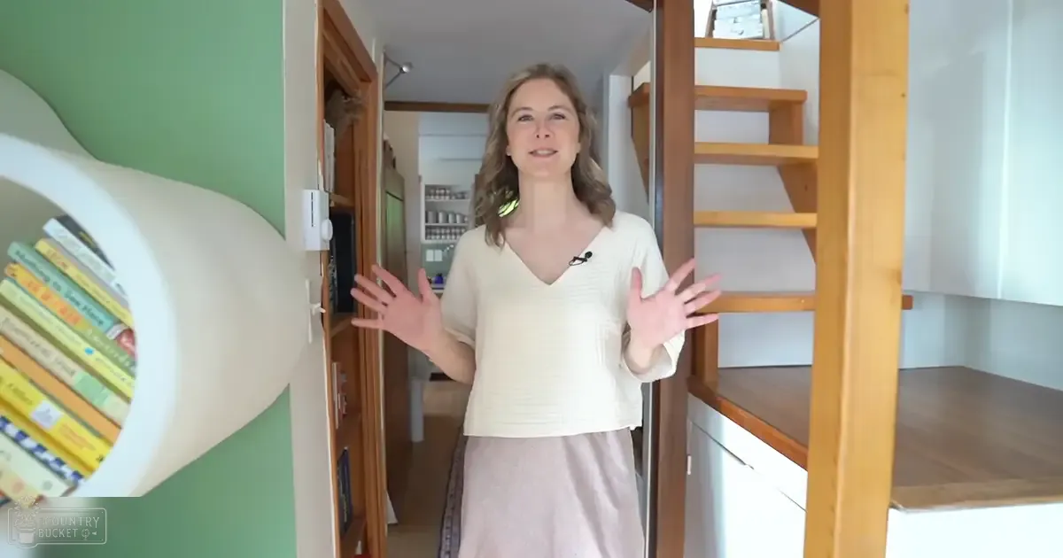 A middle-aged adult female in a casual light beige V-neck top with a pink skirt, standing indoors under natural daylight.