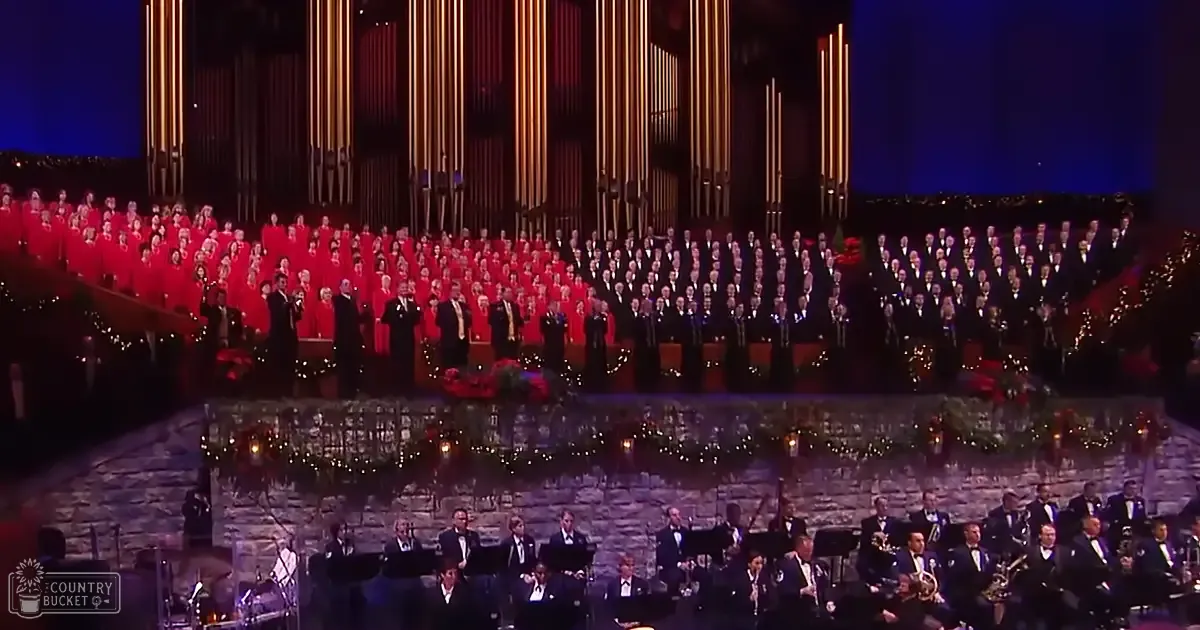 Adult males in dark suits performing at a concert hall with festive decorations, holiday season ambiance.
