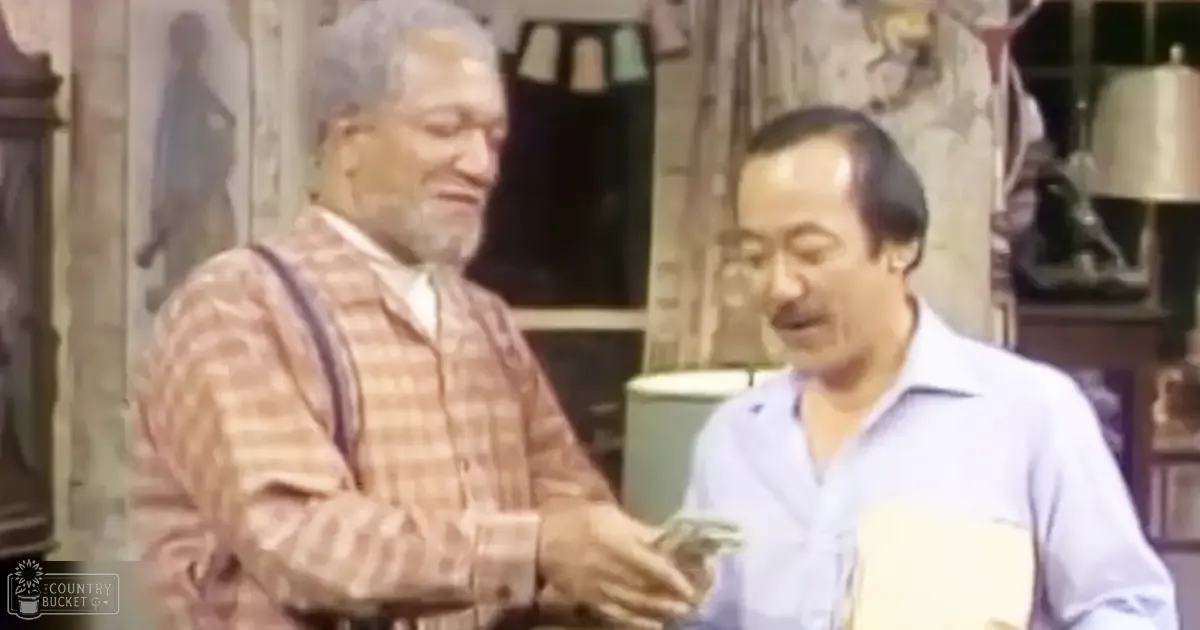 Two adult men in a home setting with muted earth tones and natural lighting, suggesting a casual interaction.