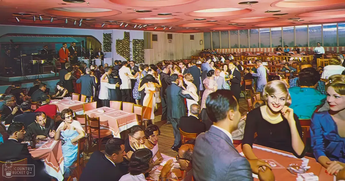 A lively social gathering in an indoor setting resembling a casino or dance hall from the mid-20th century, with adults dressed formally in dresses and suits.