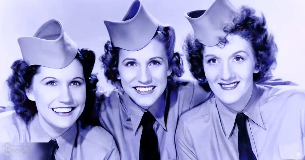 Three women in uniform attire from the mid-20th century seated indoors against a simple backdrop, wearing military-style hats and uniforms with collared shirts and dark ties.