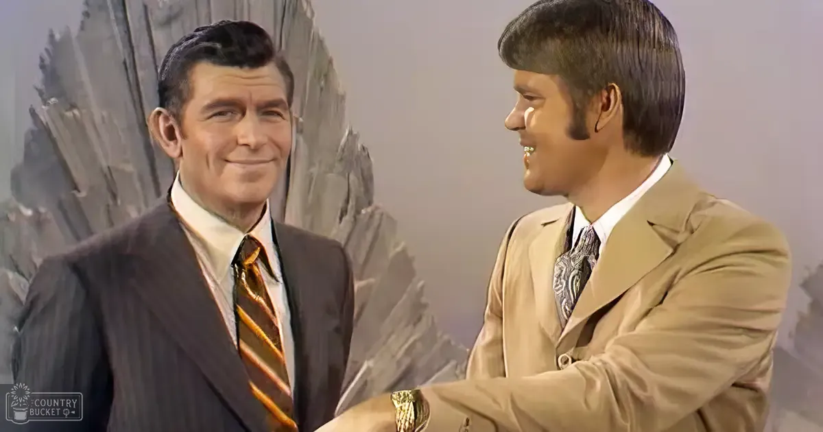 Two characters interact against a stylized rock formation backdrop, suggesting an outdoor setting within an indoor television studio environment.