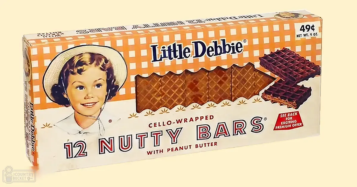 Close-up of vintage Little Debbie Nutty Bars packaging with a young girl in white attire against an off-white background, emphasizing the product's mid-20th-century design and promotional details.