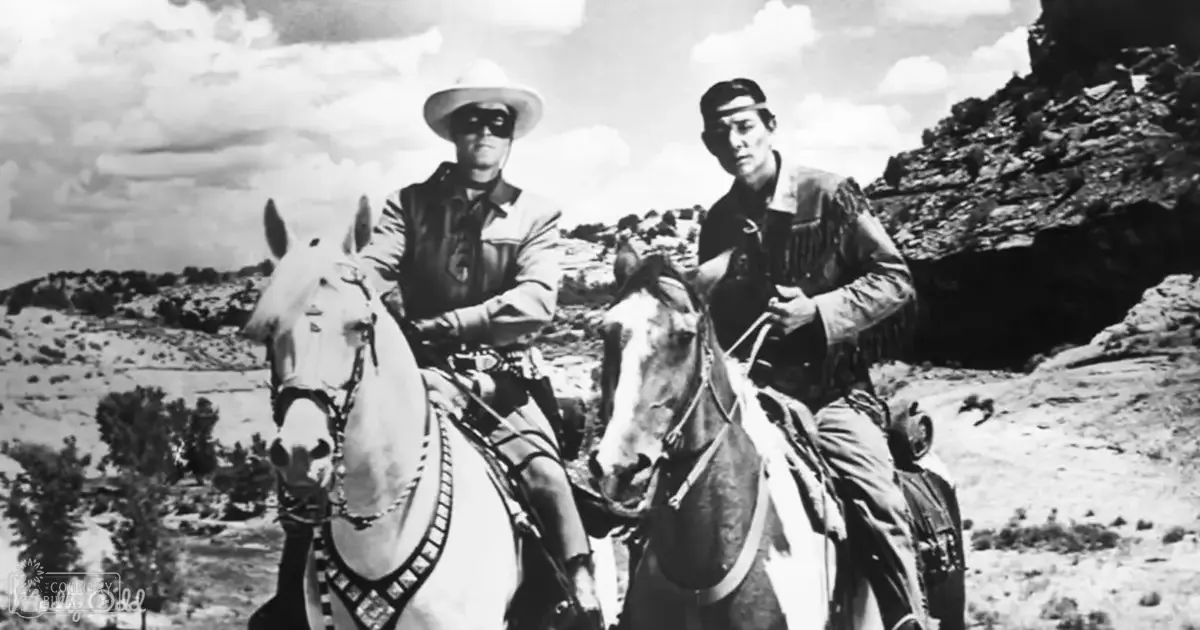 A classic Western film scene set in a rugged desert landscape, with two adult male cowboys wearing traditional attire and riding white horses under natural daylight.