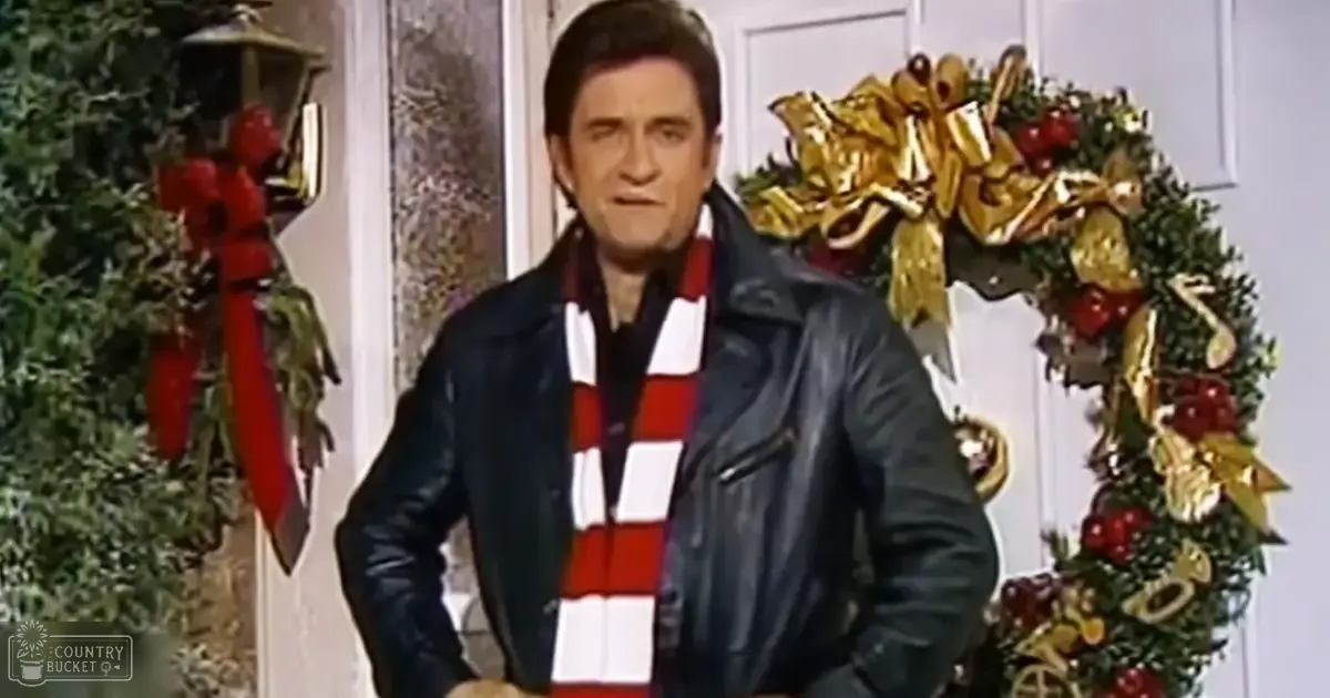 Adult male in a home setting, dressed in a dark leather jacket over a red and white striped sweater with a classic mid-20th century style.