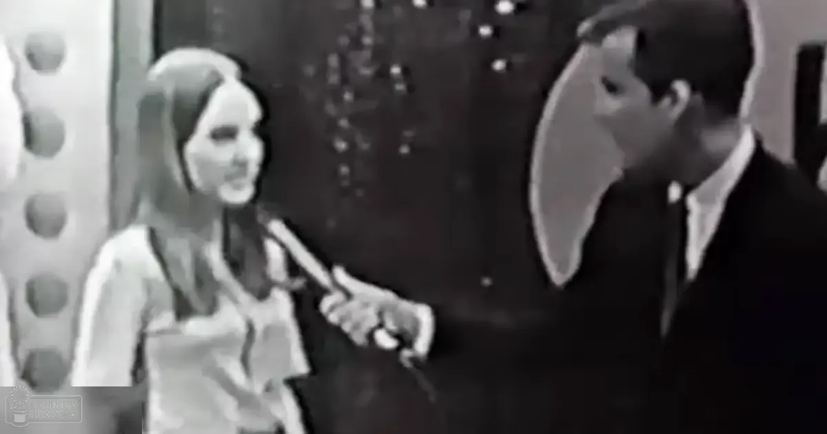 A young adult woman being interviewed by an adult male in a mid-20th-century styled setting with dark background and circular patterns.