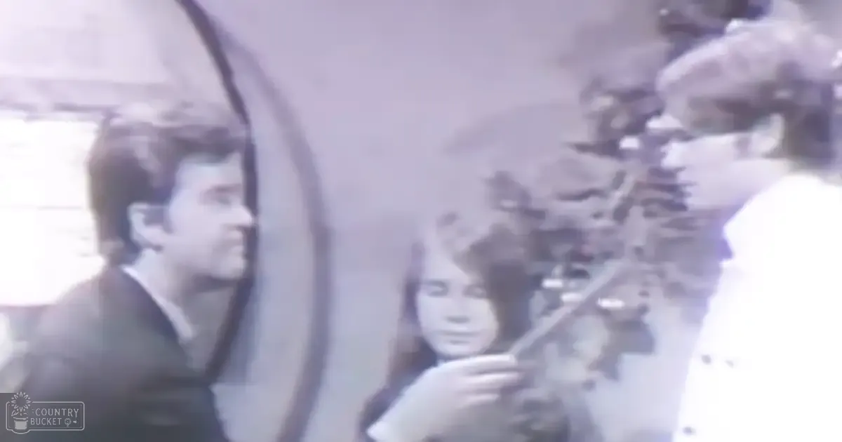 Young adult male, child, middle-aged female indoors with muted colors and possible mid-20th century clothing.