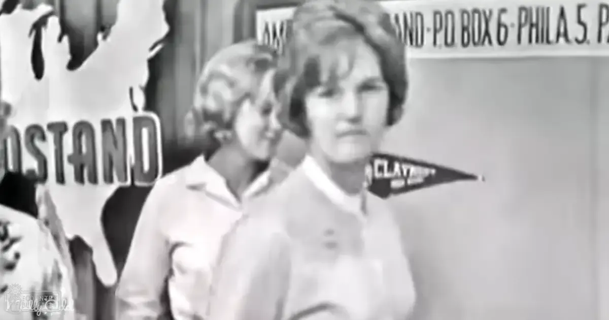 A young adult female and a child in an indoor setting with signage visible, possibly at an event or gathering; the image is black and white.