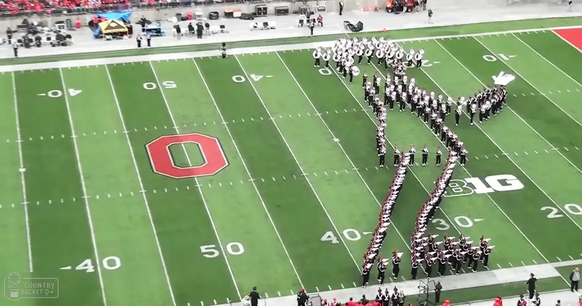 A marching band performing on a football field at Ohio State University in fall or spring attire under natural light.
