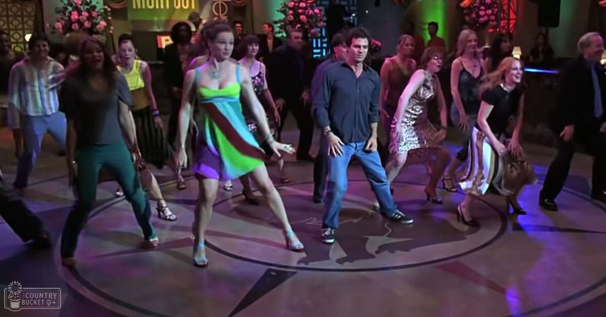A lively indoor dance scene with young adults in vibrant clothing, set against a backdrop of a 'Night Out' sign suggesting a nightclub atmosphere.