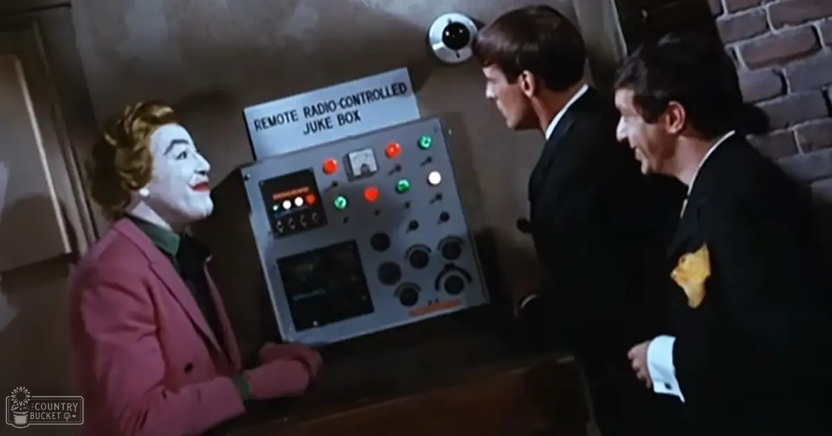 Three adults in tailored mid-20th-century fashion stand indoors near a remote radio-controlled jukebox, with brick walls and dim lighting suggesting evening or night time.