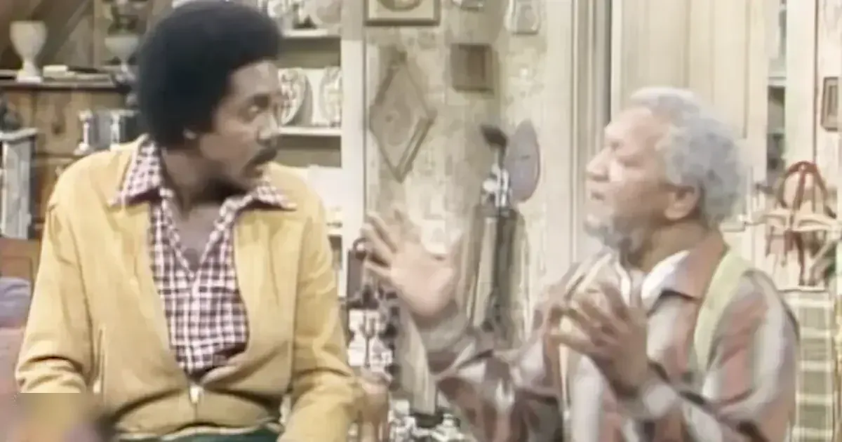 Adult male singers in a vintage mid-20th century indoor living space with shelves, mirror, and furniture.