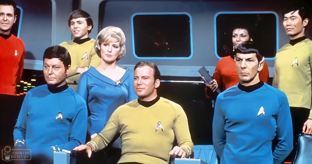 Characters from 'Star Trek' seated at a console inside the USS Enterprise, with blue and yellow uniforms prominent.