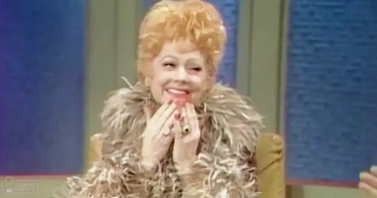 A middle-aged female in a fluffy, light-colored feathered mid-20th century-style garment indoors with blue walls and green curtains.