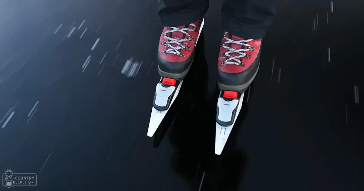 Indoor ice skating rink with dark floor, light reflections, and red-and-white ice skates.