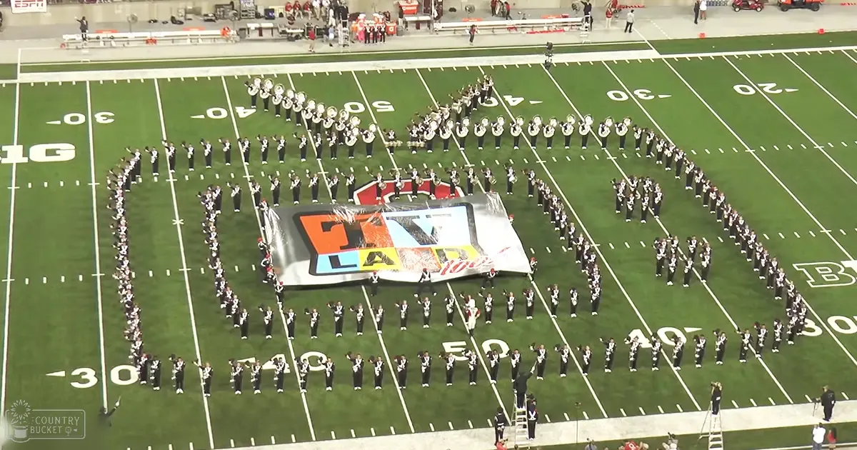 A marching band performing on a football field with clear skies above.