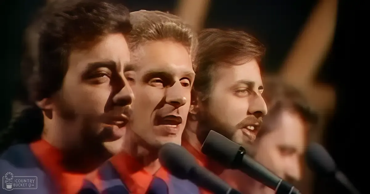 A group singing in front of microphones at an indoor event or performance venue under warm stage lighting.