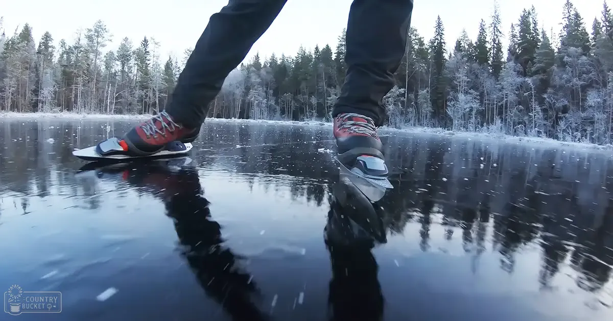 Adult male ice skating in a snowy forested area with an overcast winter light.