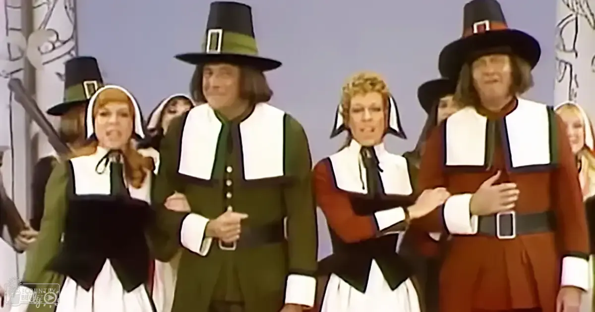 Performers in Pilgrim costumes indoors, likely for a theatrical production or performance.