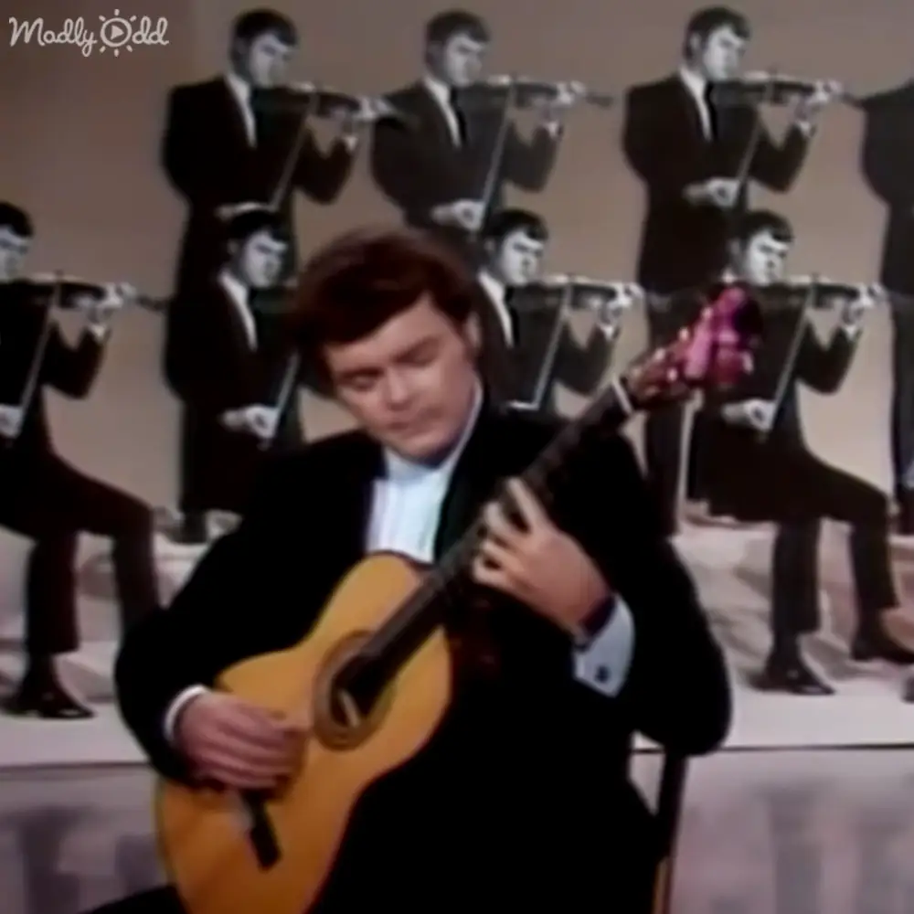 Young adult male playing an acoustic guitar in a studio setting with multiple cutout duplicates of himself.