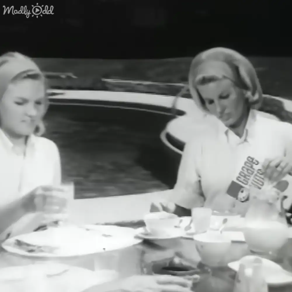 Two adults seated at a table in an indoor restaurant setting with dim lighting and black-and-white imagery.