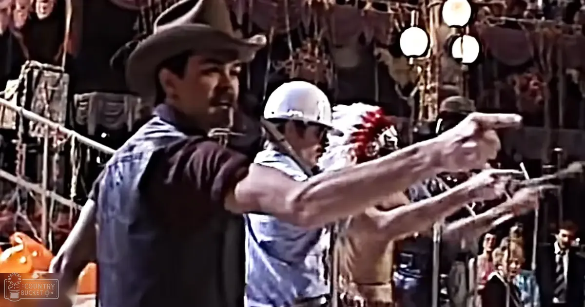 Adult male in a dark shirt, light blue denim vest, wide-brimmed cowboy hat points a gun in an old western town setting with wooden scaffolding and hanging lanterns.