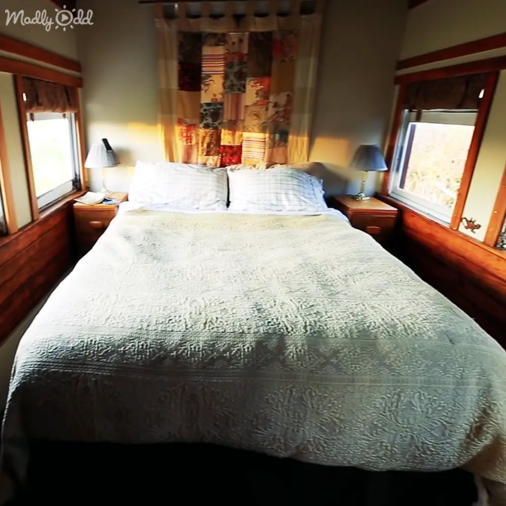 A cozy, rustic bedroom scene with wooden bedside tables, patterned bedding, and earthy tones.