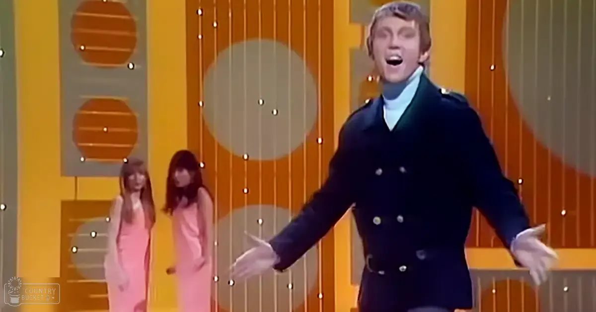 A young adult male performer in a dark blue double-breasted coat stands at center stage, with two children in vintage dresses flanking him against an indoor retro-themed backdrop.