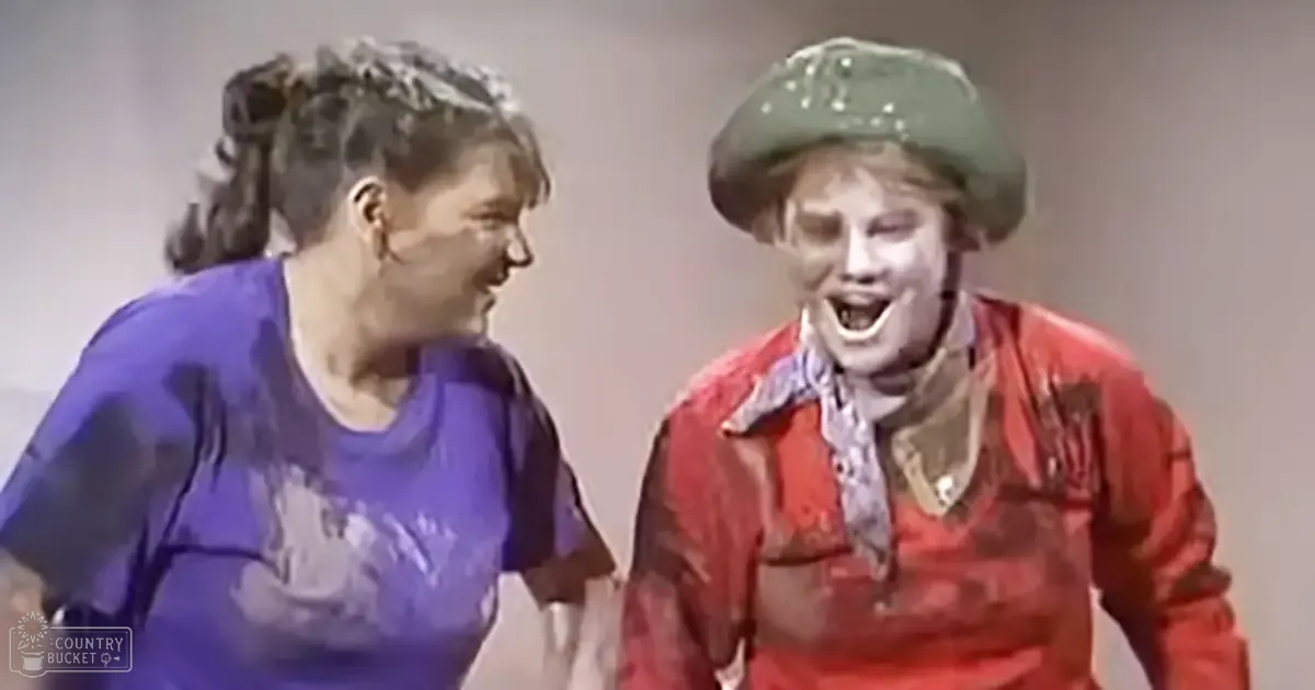 A comedic scene from a performance or skit, possibly in a studio setting with two young adults engaging in dialogue.