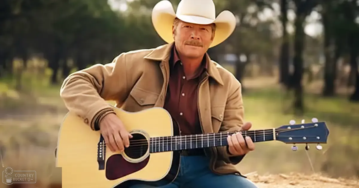 A middle-aged adult male in an outdoor setting with a light brown acoustic guitar, surrounded by trees and natural light.