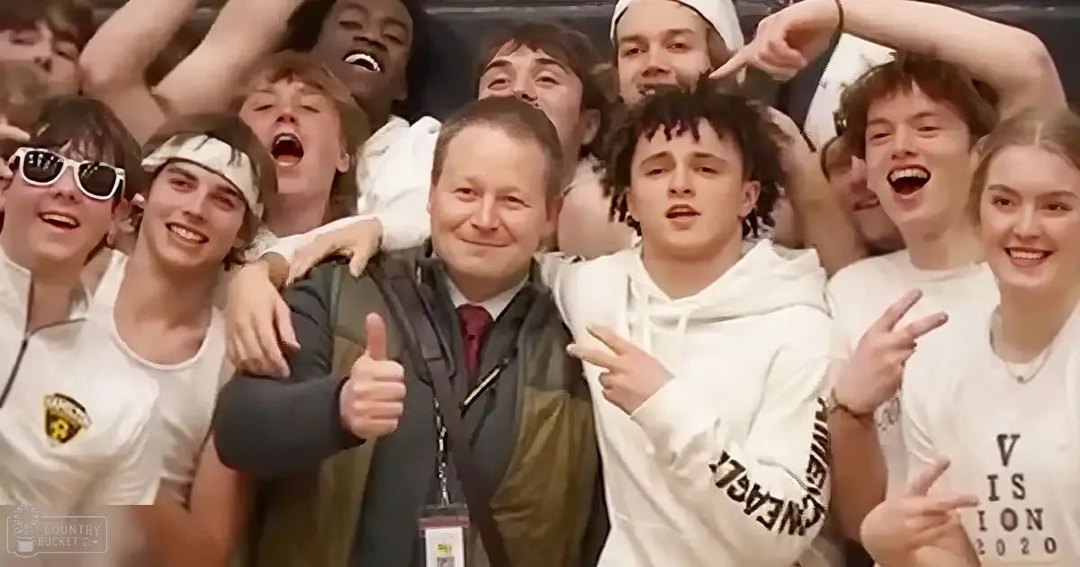 Group photo of adults and teenagers at an indoor event with casual attire, possibly a school or sports gathering.