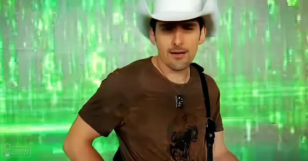 Young adult male wearing a brown t-shirt with a graphic print and white cowboy hat, set against a green glitchy background.
