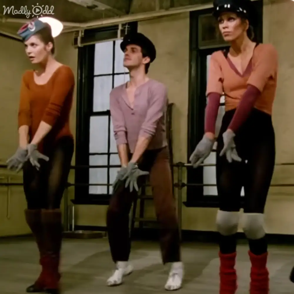 Adults performing dance in an indoor studio with natural light streaming through windows.