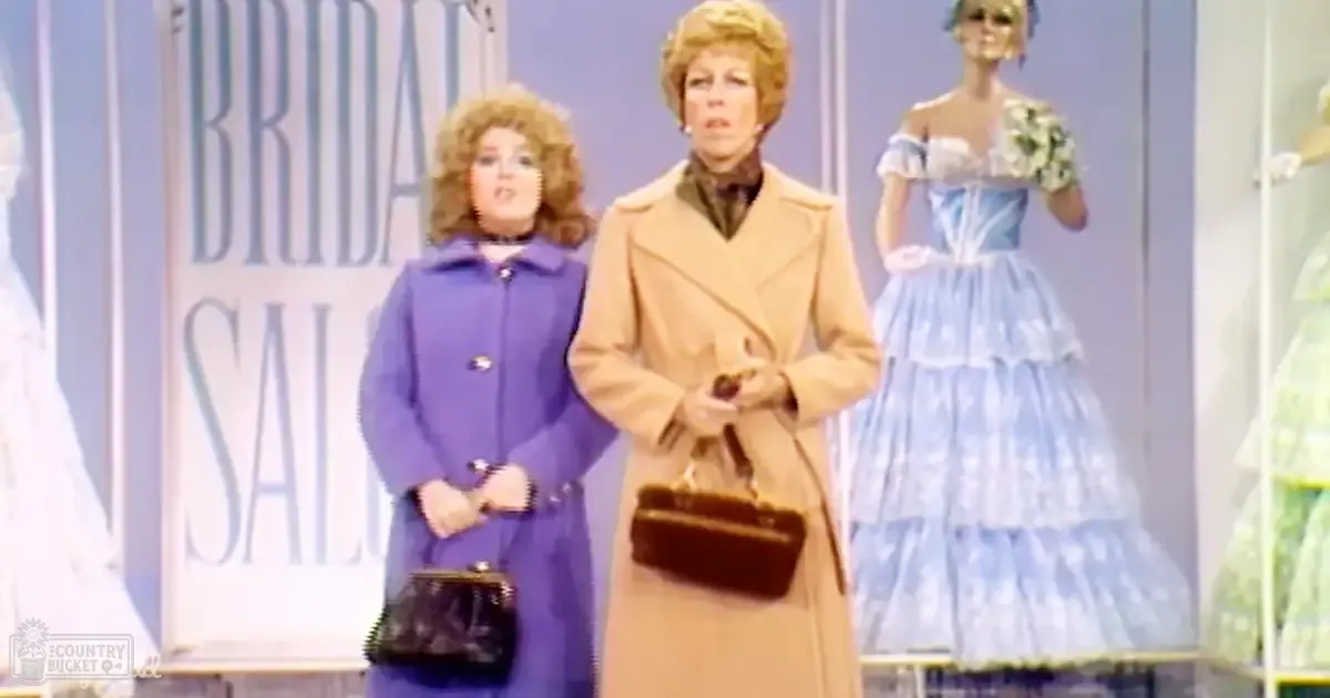 Two women, one wearing a purple coat and the other in beige, stand against mannequins displaying wedding attire under bright indoor lighting.