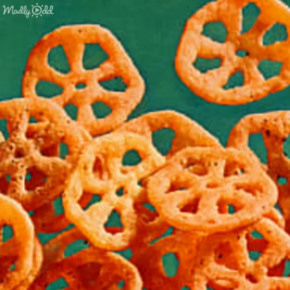 Pile of pretzels on a green surface, likely in an indoor food preparation area.