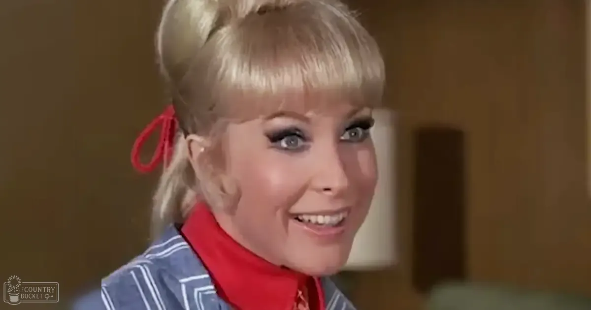 A young adult female in an indoor setting wearing a striped garment with vertical white stripes on a blue background, suggesting the 1960s or early 1970s style.