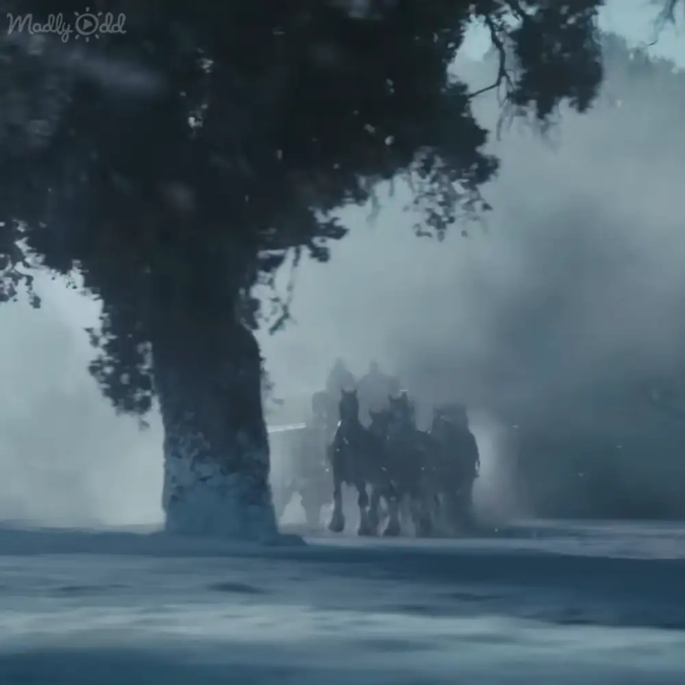 A horse-drawn carriage in a foggy wintry setting with dark-colored horses and muted blues and grays dominating the scene.