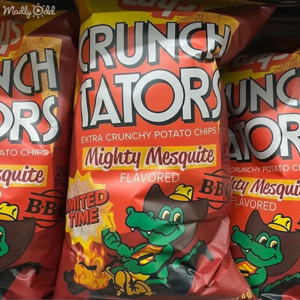 Bags of Crunch Tators Mighty Mesquite flavored potato chips in a store or grocery setting with red, yellow, black, white, and orange packaging.