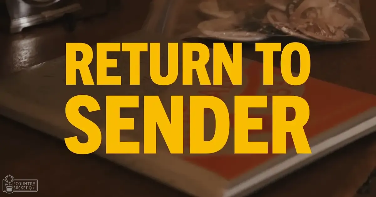 An open book titled 'RETURN TO SENDER' with bold yellow text on a dark brown cover, placed on what appears to be a wooden desk or table in an indoor setting.