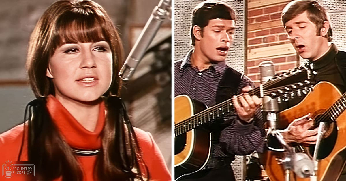 A young adult female singer in a red garment and black leather jacket performs with two young adult male guitarists wearing dark patterned shirts and jackets, set against an indoor recording studio backdrop.