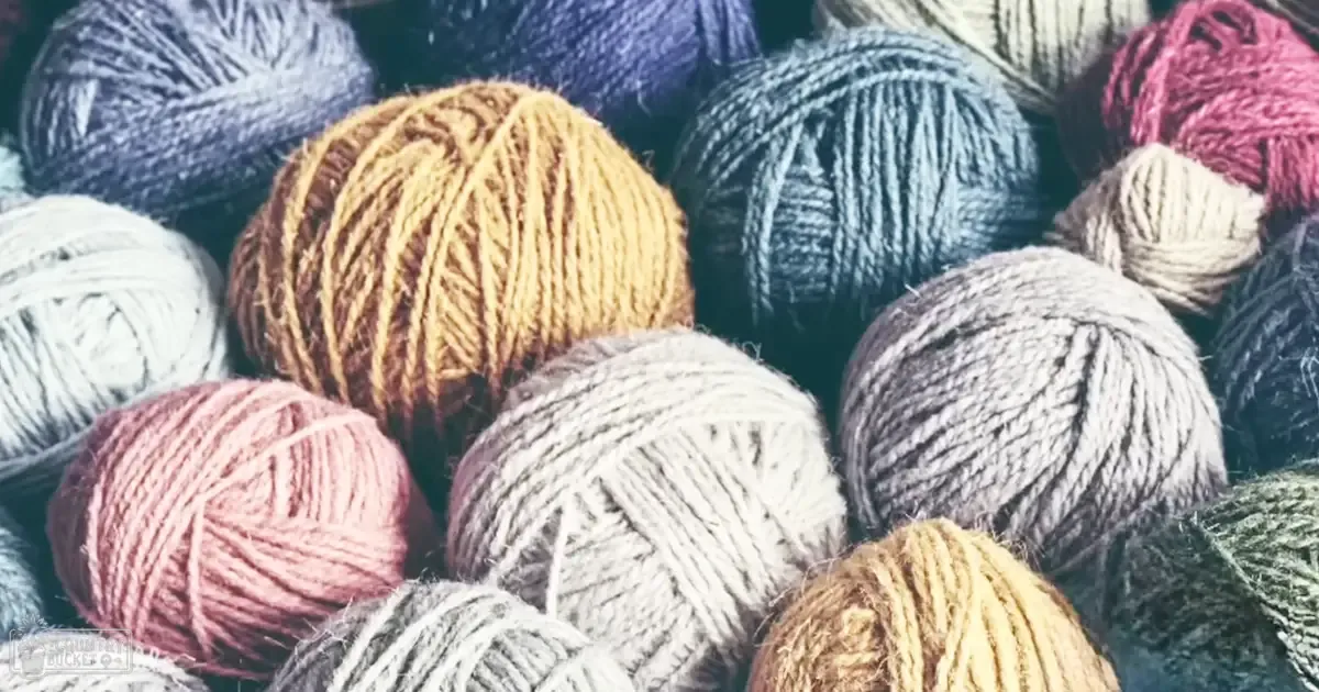 Various colored yarn balls in an indoor craft room setting with artificial lighting.