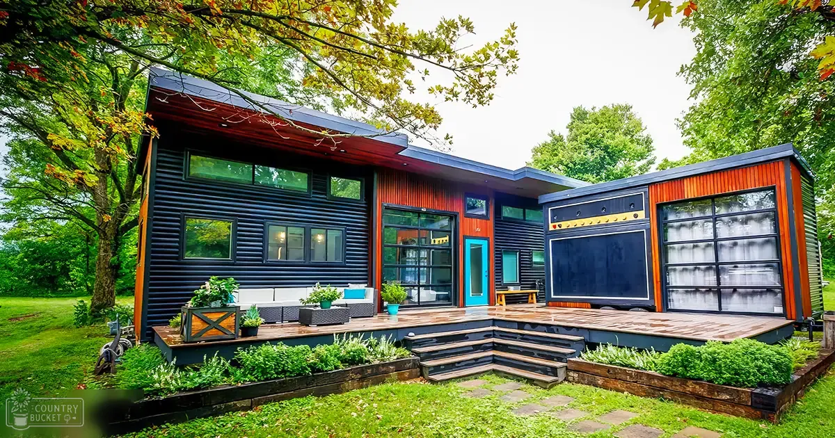 A modern house with a unique design situated in a lush park-like setting surrounded by trees during daytime with clear weather.